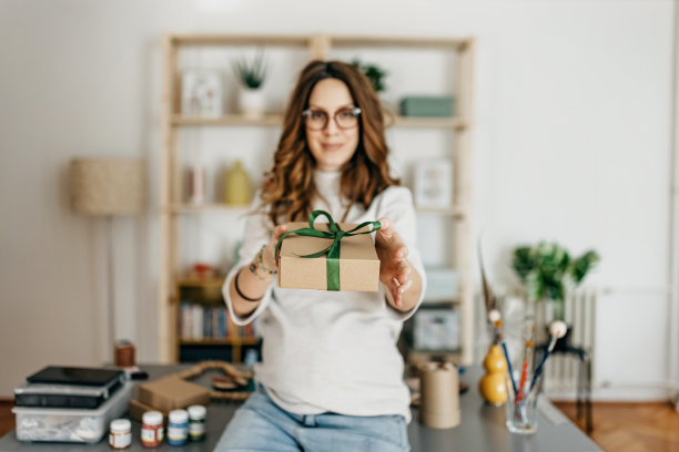 年轻的孕妇小企业主在工作室准备礼品盒图片下载