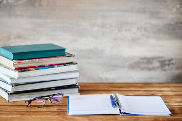 桌上有一堆书，一个笔记本，一支笔图片下载