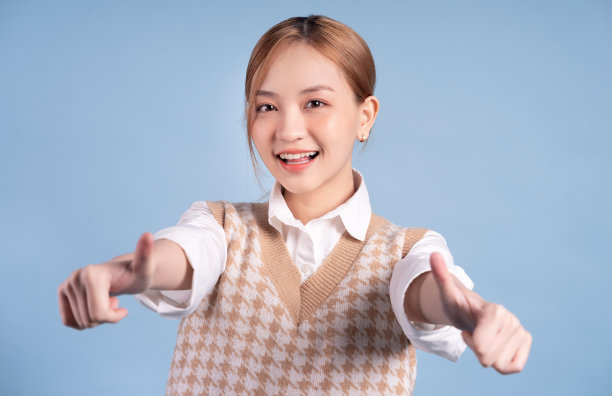 年轻的亚洲青少年在蓝色的背景图片下载