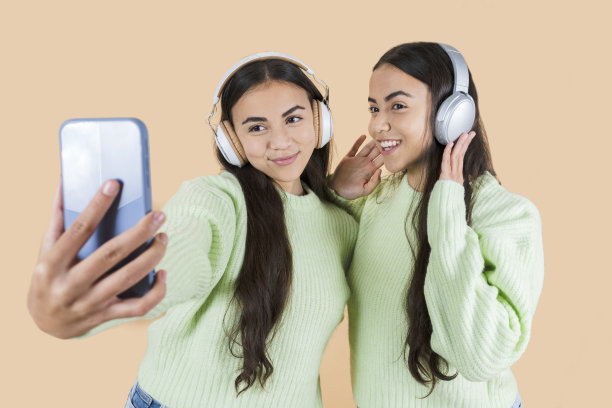 双胞胎姐妹听音乐用手机拍照图片下载