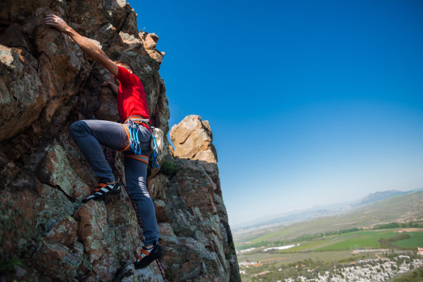 极限运动。征服岩石时的攀岩者图片下载