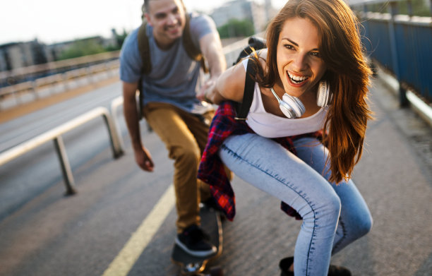 年轻夫妇在户外玩滑板和长板的照片图片下载