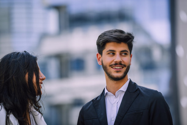 一对年轻的商务夫妇在办公楼附近散步图片下载