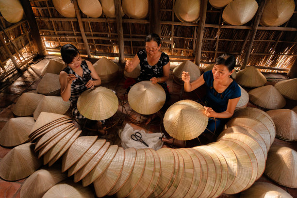 一群越南妇女正在家中制作传统的圆锥形帽子图片下载