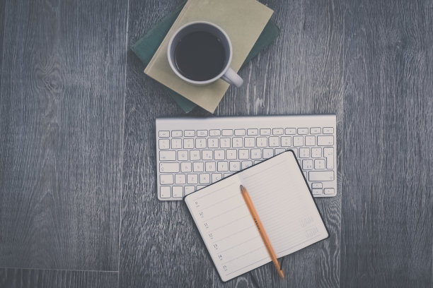桌面视图与键盘，铅笔，议程和书籍。为智能工作或家庭教育准备的桌子。组织、远程工作、学习、创造力、生产、优柔寡断、观念混乱。图片下载