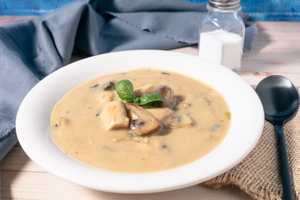 自制奶油鸡肉蘑菇汤或法式炖鸡肉，放在木桌上的白色汤碗里。高的观点。图片下载
