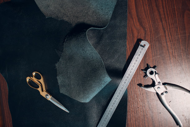 制革女工在车间制作皮革制品。皮革工匠的工作过程图片下载