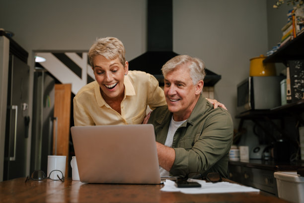白种人老夫妇在家里工作时微笑图片下载