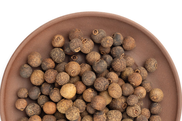 香料多香果在白背景粘土板。平的。关闭了。宏。健康饮食的概念图片下载