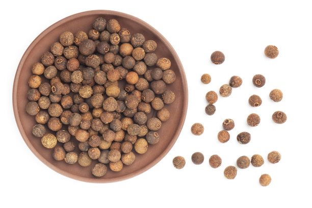 香料多香果在粘土板和中型束在白色背景孤立。平的。宏。健康的饮食概念图片下载