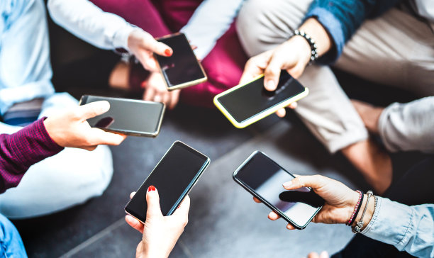 使用移动智能手机的手部特写- z世代朋友用现代智能手机在社交媒体网络上分享照片的细节-科技生活的生活概念-选择聚焦左下方设备图片下载