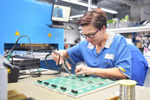 友好的女性，在微电子制造工厂工作-组件组装和焊接图片下载