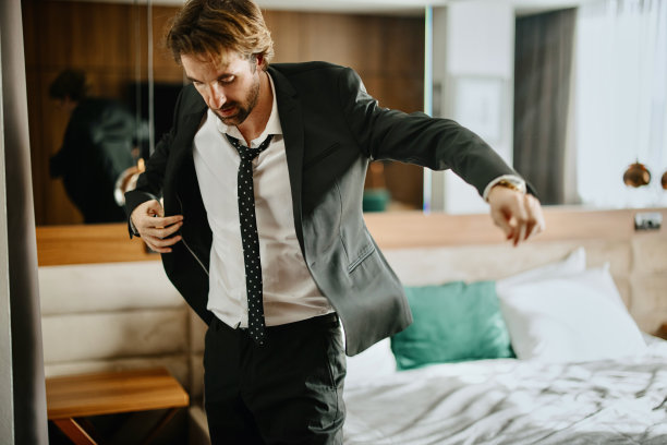 英俊的商人在酒店房间里穿衣服图片下载