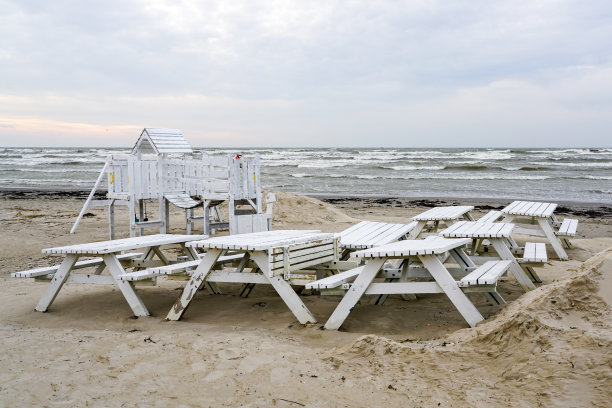 白色的木凳和桌子在灰色的大海背景下的沙丘上图片下载