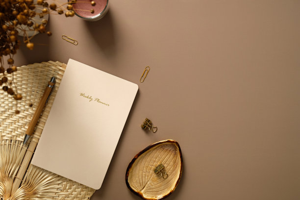 美观的家庭办公桌。女性工作空间，每周计划，钢笔，办公文具，蜡烛，干花。平躺，俯视图。图片下载