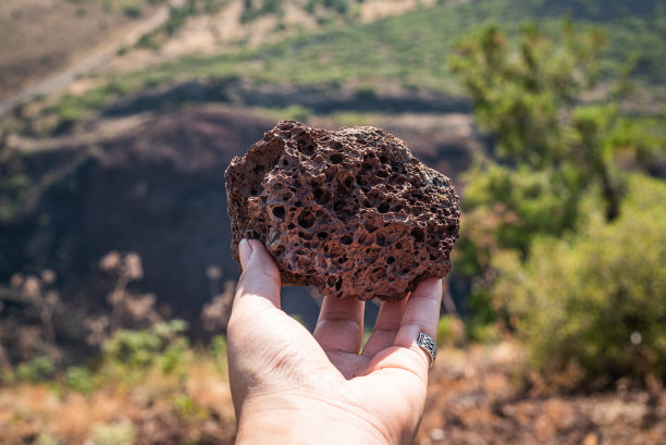 女人手里拿着火山岩。库拉地质公园，马尼萨，土耳其。图片下载