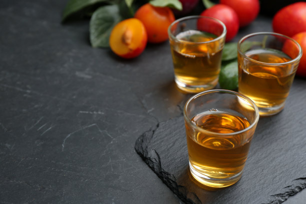 黑桌上摆着美味的梅子酒。自制烈性酒图片下载