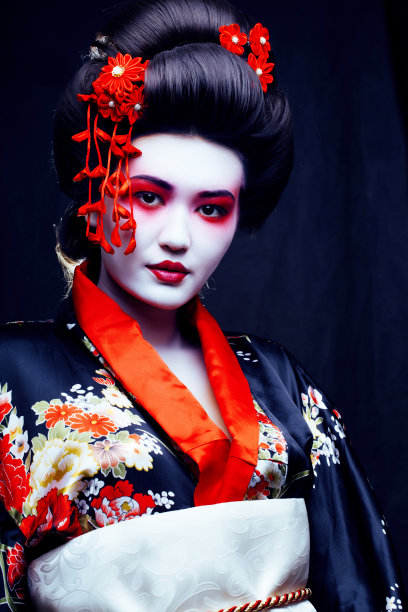 年轻漂亮的艺妓穿着带有樱花和装饰的和服图片下载