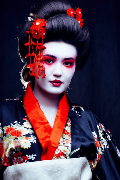 年轻漂亮的艺妓穿着带有樱花和装饰的和服图片下载