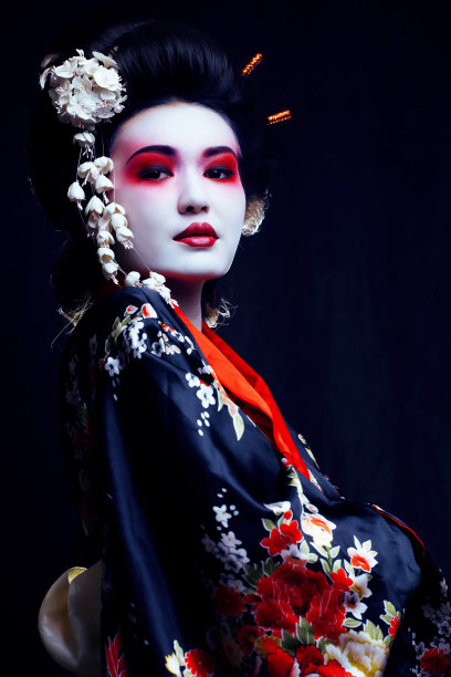 年轻漂亮的艺妓穿着带有樱花和装饰的和服图片下载