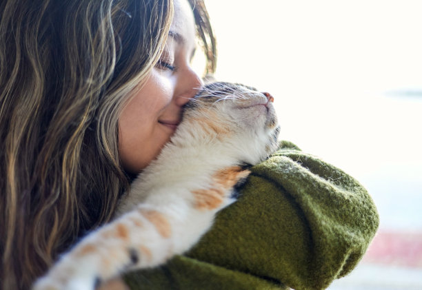 美丽的女人在家里亲吻她的猫图片下载