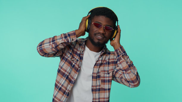 开朗迷人的男士，戴着耳机听音乐，跳迪斯科图片下载