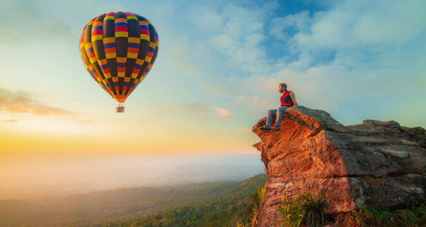 一个年轻男子坐在气球节的侧视图图片下载