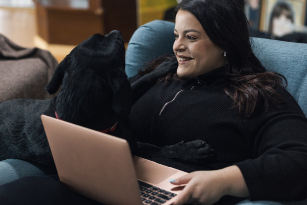 年轻漂亮的丰满女人和宠物狗玩耍图片下载