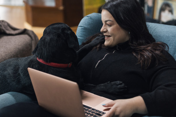 年轻的丰满女子笑着看着她的狗图片下载