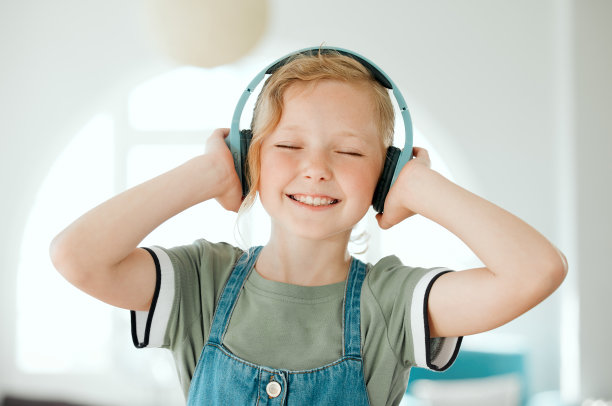 可爱小女孩在家戴耳机听音乐的竖版照片图片下载