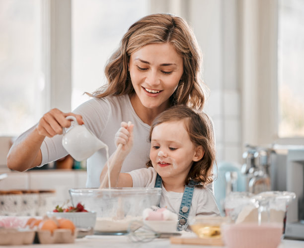 这张照片拍摄的是一对母女在家里的厨房里烤面包图片下载