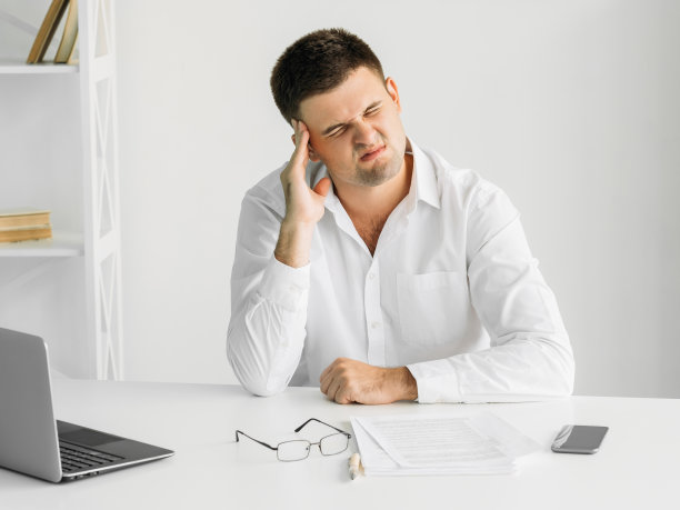 精疲力竭的工作折磨着男人头痛沮丧图片下载