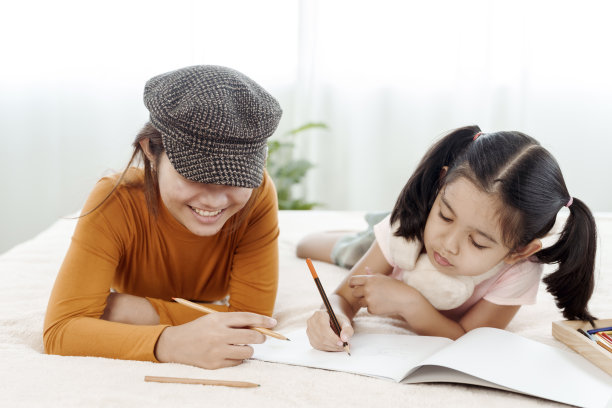 4k 50fps快乐的姐妹女孩们帮助可爱的幼儿园孩子们画画，在床上一起玩耍。用彩色铅笔在纸上画画。幸福概念家庭和学习图片下载