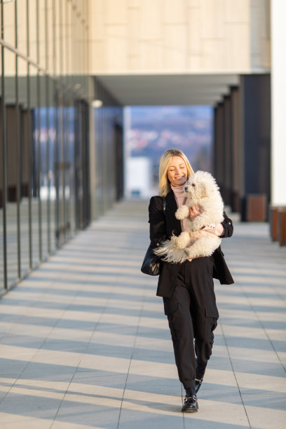 年轻的女商人带着她的狗在办公大楼前图片下载
