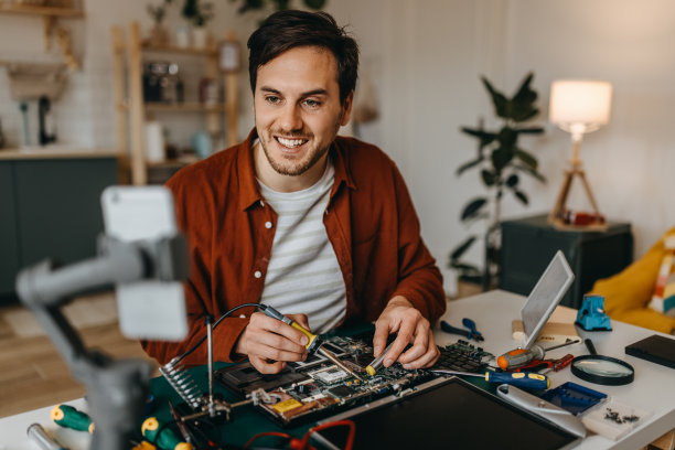 年轻人在家修笔记本电脑时拍视频图片下载