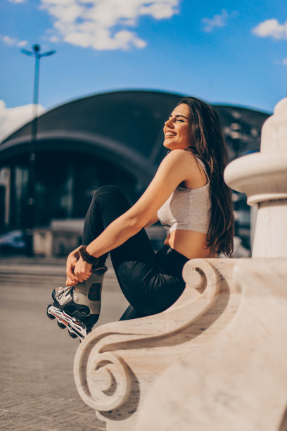 快乐快乐的年轻女子在城里骑着旱冰鞋图片下载