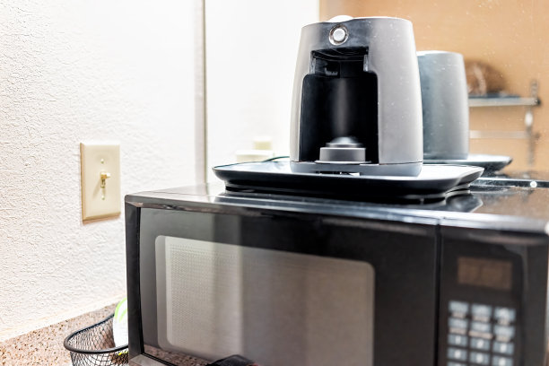 酒店汽车旅馆的厨房在房间套房，微波炉和咖啡机在柜台上，没有人接近旧机器图片下载