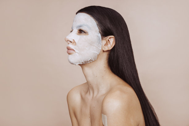 美丽的女人用胶原蛋白凝胶面膜护理面部图片下载