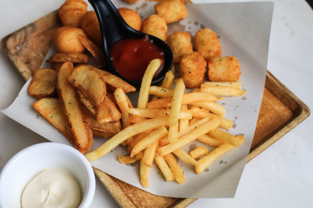 在木桌背景上放薯条或加番茄酱的薯条。在烤箱里自制烤的图片下载