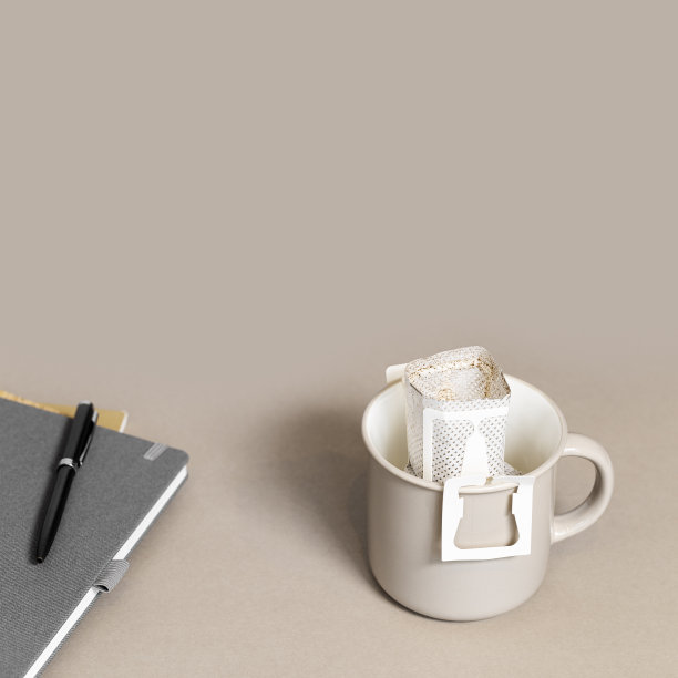 滴滤咖啡袋与磨碎的咖啡在大杯子在办公室桌上，抄本，笔，纸袋滴滤咖啡煮米色背景，在工作时间咖啡休息图片下载