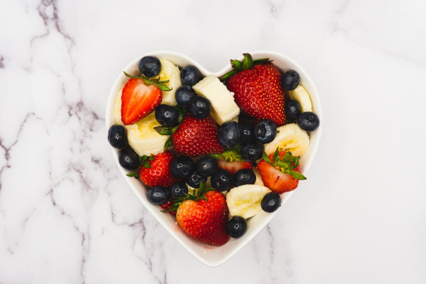 大理石柜台上的草莓、香蕉和蓝莓碗图片下载