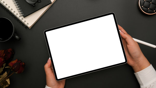 一个女商人的手在黑色的办公桌上拿着平板触控板图片下载