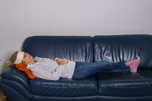 受伤的头部缠着绷带的女人躺在沙发上图片下载