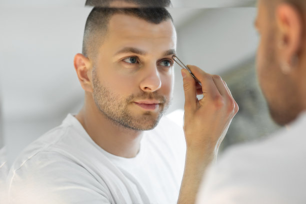 男人在镜子前拔眉毛图片下载