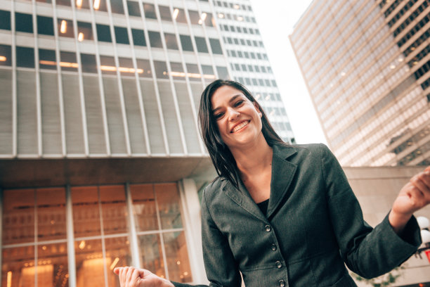 快乐的女商人在城市里欢腾图片下载