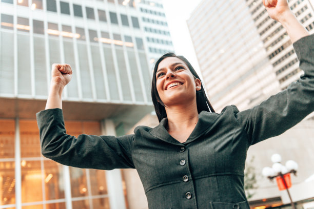 快乐的女商人在城市里欢腾图片下载