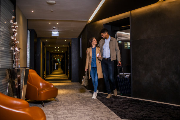 一对兴高采烈的夫妇走出酒店的电梯图片下载