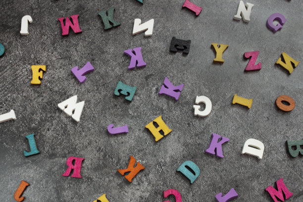 黑色混凝土背景上的英语字母的彩色木制字母。字母组合字母表中的字母组合很多木头字母。封面、明信片、帖子等的模板图片下载