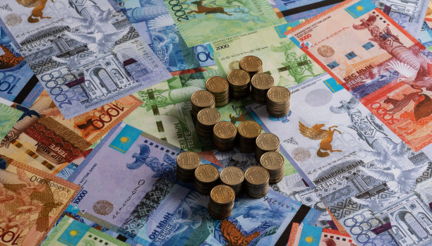 面值为100哈萨克坚戈的硬币，折叠成美元符号和哈萨克纸币的形式图片下载