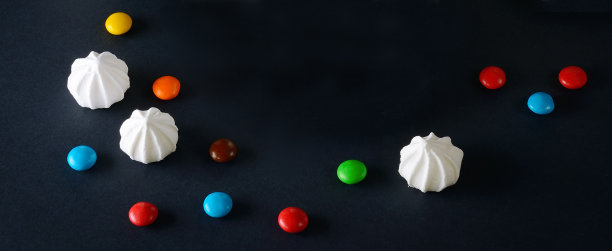 黑色背景上的蛋白酥和巧克力酱。文本的空闲空间。图片下载